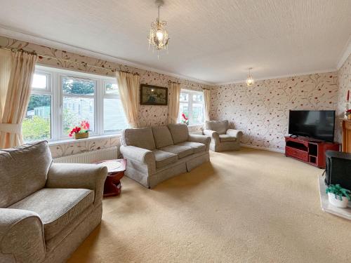 a living room with two couches and a television at Tredegar in Newton Stewart