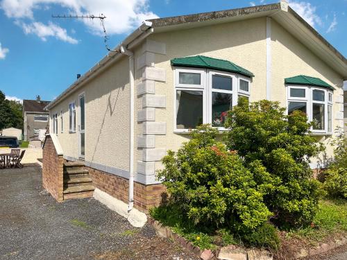 aige house with a window and bushes in front of it at Tredegar in Newton Stewart