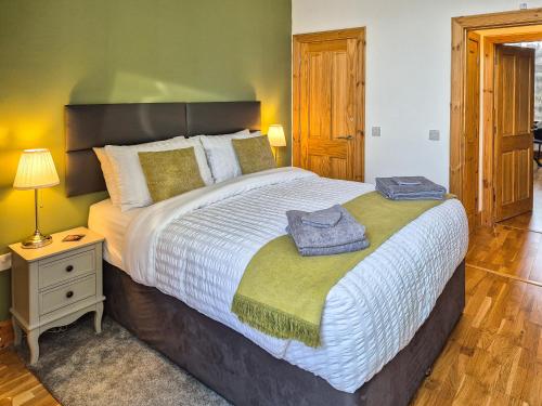 a bedroom with a large bed with two towels on it at Lena's Corner in Dunoon