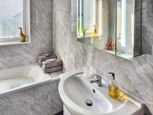 a bathroom with a sink and a bath tub at Lena's Corner in Dunoon