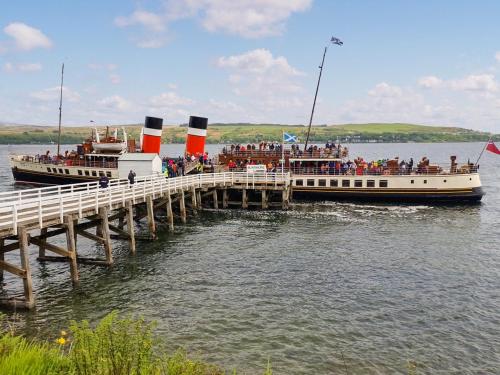 a large boat on the water next to a pier at Lena's Corner in Dunoon