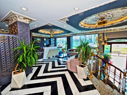 eine Lobby mit schwarz-weißem Bodenbelag und Pflanzen in der Unterkunft Grand Best Nobel Hotel İstanbul in Istanbul