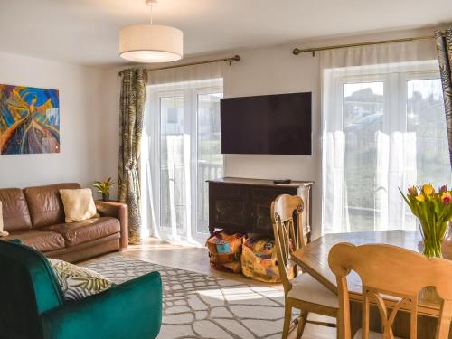 a living room with a table and a television at Wild Lupin in Kessingland