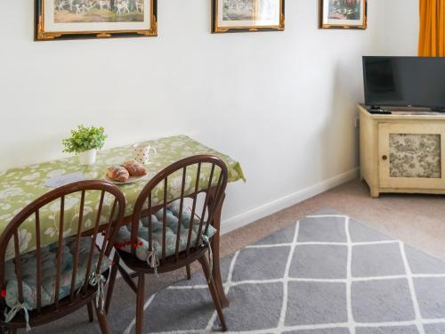 a dining room table with two chairs and a television at Waterside Park Annex in Kingsbridge