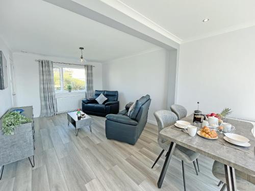 a living room with a table and a couch at Driftwood Cottage in Portpatrick