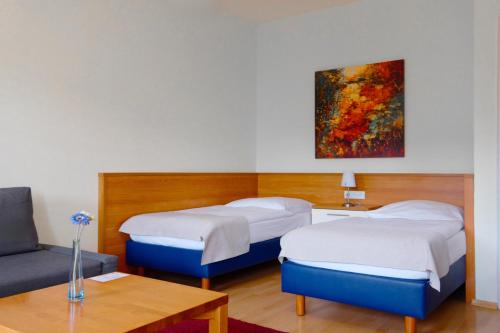 a hotel room with two beds and a couch at Hotel Trierer Hof in Koblenz