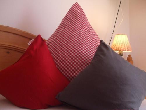 a group of three pillows sitting on a bed at Ferienwohnung Alpensonne in Oberstdorf