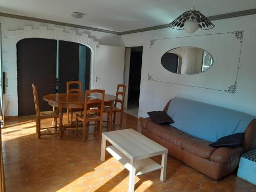 a living room with a couch and a table at Gîte meublé 10 personnes in Donges