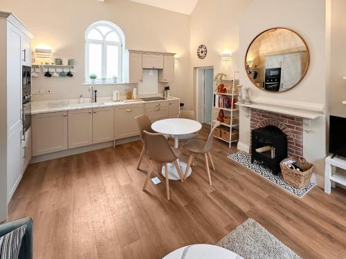 a kitchen with a table and a fireplace at The Church Rooms in Wenhaston