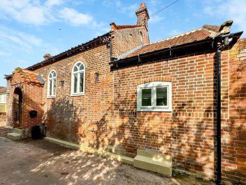 a brick building with two windows on the side at The Church Rooms in Wenhaston