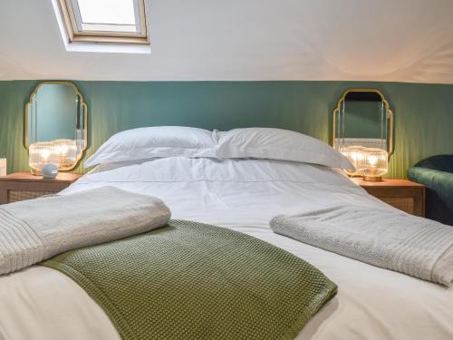 a bedroom with a large white bed with two mirrors at Barn Owls Nest-Uk39432 in Dronfield