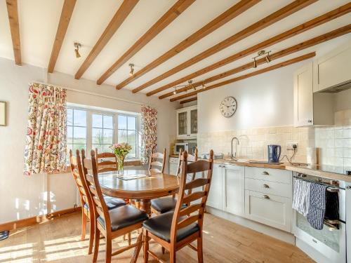 a kitchen with a table and chairs in a room at Cwm Eithin Cerbid - Cottage in Llanhowell
