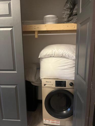 a small room with a washing machine and a bed at Cottage by the cabin in Springfield