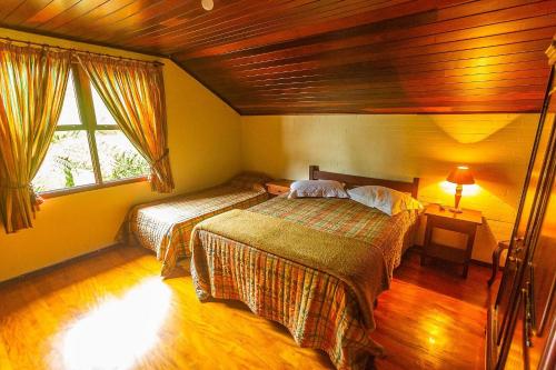 a bedroom with two beds and a window at Sítio Bem me Quer seu conforto e relax na Serrinha in Penedo
