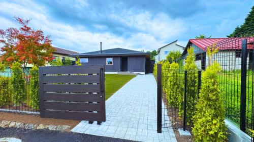 a black fence with a gate in front of a house at トライハク軽井沢 神楽-かぐら in Karuizawa
