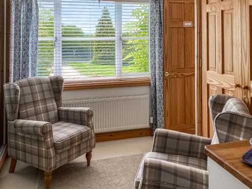 a living room with two chairs and a window at Tanglemere in Badsey