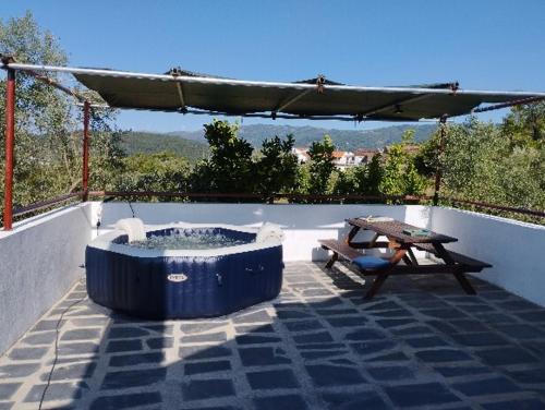 a blue tub sitting on a patio with a picnic table at Quinta Samoura in Góis