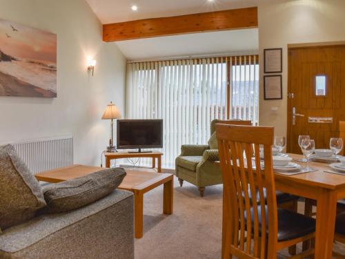 una sala de estar con un sofá y una mesa en Sandpiper, en Carnforth