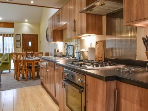 a kitchen with wooden cabinets and a stove top oven at Sandpiper in Carnforth