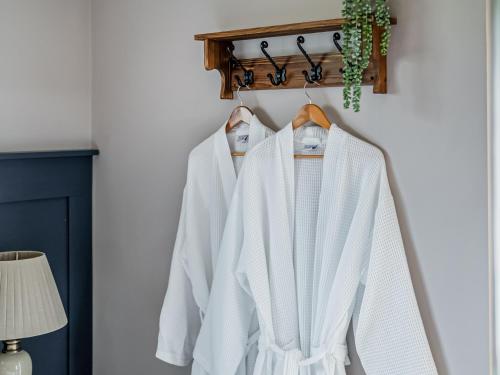 a row of white jackets hanging on a rack at Cuckoo Lodge - Uk42541 in Winforton
