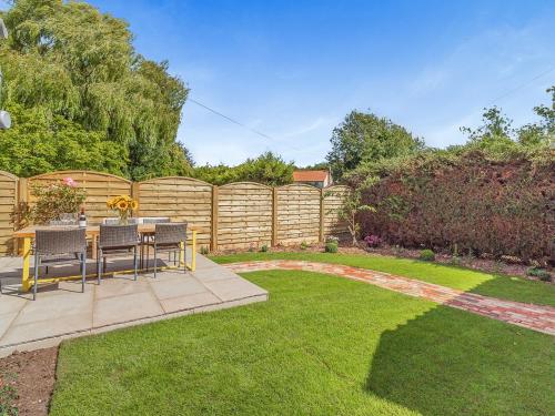 a garden with a table and chairs and a fence at Queens Barn in Wortham