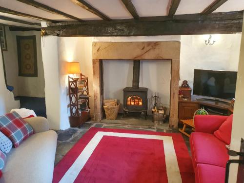 a living room with a couch and a fire place at Garden Cottage in Threlkeld