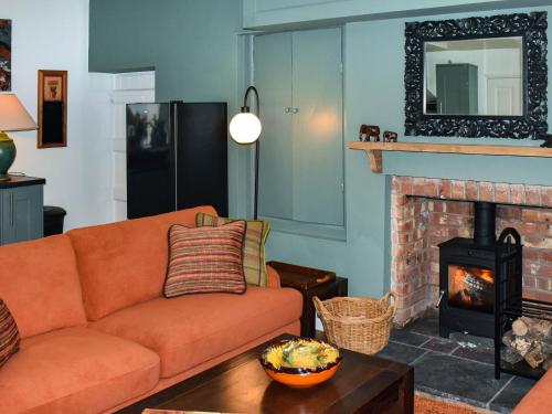 a living room with a couch and a fireplace at Ddwylig Isaf Farmhouse - Uk48624 in St Asaph
