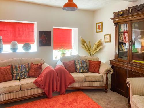a living room with two couches and two windows at Ddwylig Isaf Farmhouse - Uk48624 in St Asaph