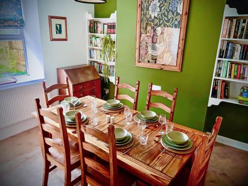 a wooden table with chairs and plates on it at Ddwylig Isaf Farmhouse - Uk48624 in St Asaph