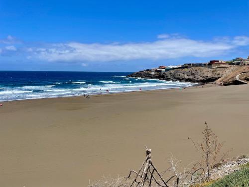 a beach with people walking on the sand and the ocean at Surf-Check House - 3 min walking to the Beach in Playa del Hombre