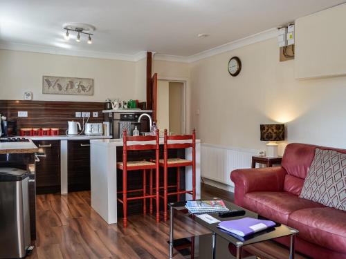 a living room with a couch and a kitchen at The Granary - Uk45181 in Newcastleton