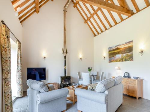 a living room with two chairs and a table at Chapel Barn - Uk46738 in Shapwick