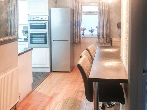 a kitchen with a wooden table and a refrigerator at Moor View in Newton Abbot