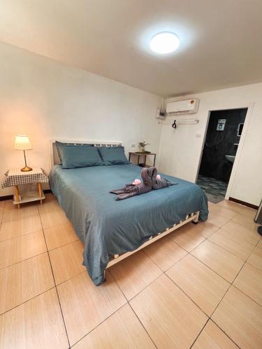 a bedroom with a large bed with a blue comforter at Kama Siri Koh Kood in Ko Kood