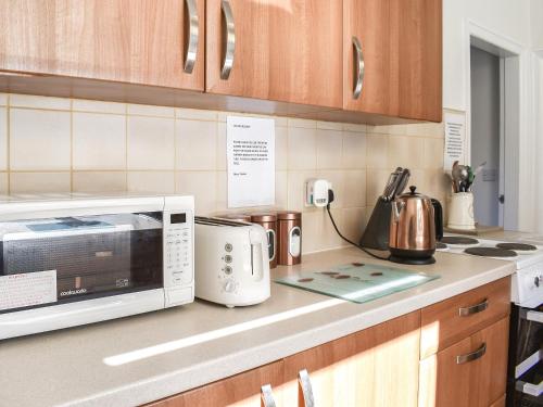 a kitchen counter with a microwave and a tea kettle at Holme Valley Cottage in Holmfirth