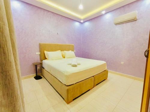 a bedroom with a bed in a purple wall at SABOR FAMILY APARTS -Jaouharat Al Atlas in Marrakech