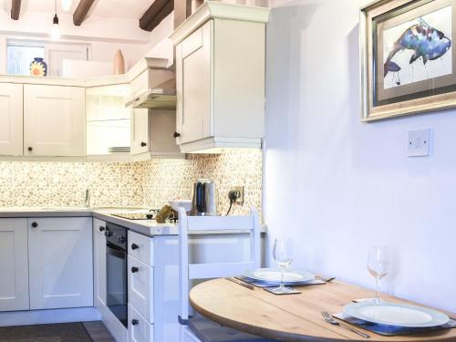 a kitchen with a wooden table with two wine glasses at Sea Dog Cottage - Uk42479 in Whitby