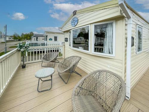 a deck with three chairs and a table and a clock at Au Bords Du Lac - Uk49028 in Tattershall