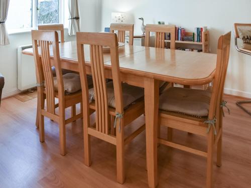 a wooden table with four chairs and a wooden table at Chy Morvoren in Falmouth