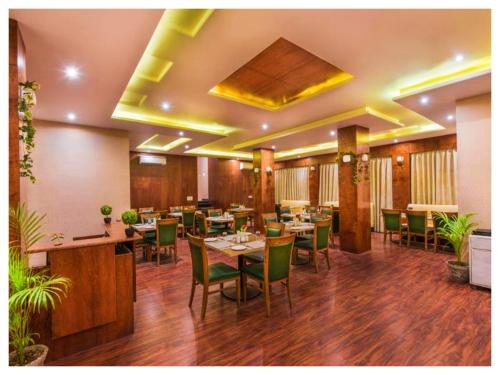 a restaurant with tables and chairs in a room at Manisha मनीषा Gaya in Gaya