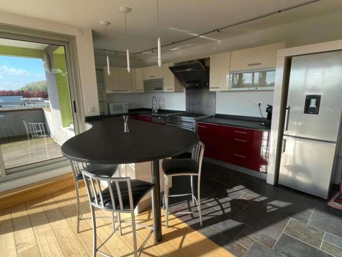 a kitchen with a table and chairs and a refrigerator at ibis Styles Bethune Bruay la Buissière in Bruay-la-Buissiere