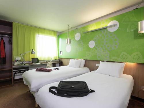 a hotel room with two beds with a suitcase on them at ibis Styles Bethune Bruay la Buissière in Bruay-la-Buissiere