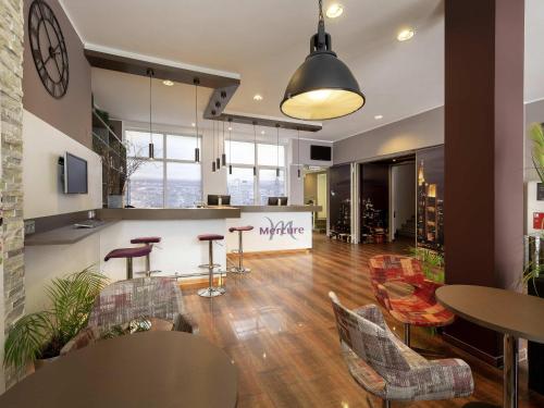 una oficina con mesas y sillas y un mostrador en Mercure Frankfurt City Messe, en Frankfurt