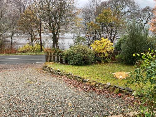 a road with a fence on the side of a street at Alt Na Blathaich in Coirantee