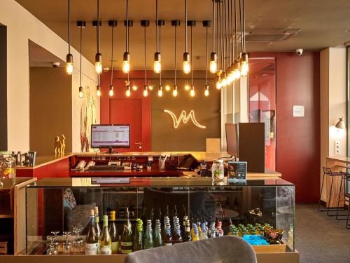 a restaurant with a bar with bottles of wine at Mercure Barcelona Condor in Barcelona