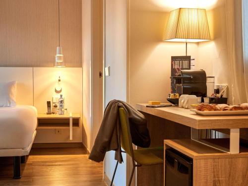 a room with a desk and a bed and a room with a table at Mercure Barcelona Condor in Barcelona