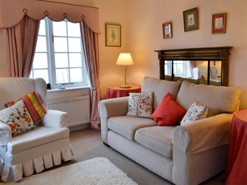 a living room with a couch and a chair at White Rose Cottage in Robin Hood's Bay