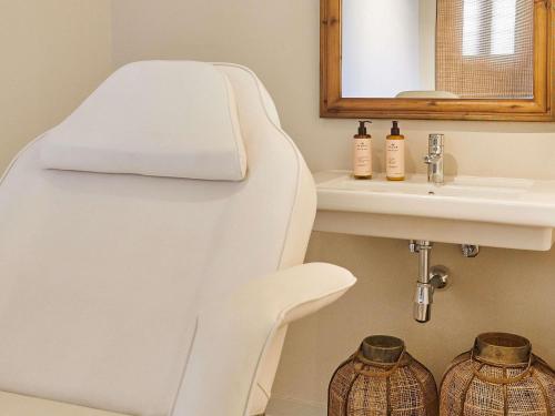 a bathroom with a white tub next to a sink at Mercure Barcelona Condor in Barcelona