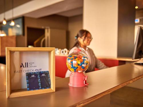 a girl sitting at a table with a candy ball in front of a clock at Mercure Barcelona Condor in Barcelona