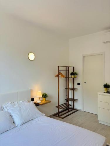 a white bedroom with a bed and a desk at BluBay in Manarola